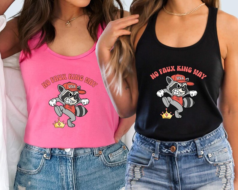 May include: Pink and black tank tops with a raccoon graphic. The raccoon wears a red hat and shirt, and a gold crown. The text "NO FAUX KING WAY" is above the raccoon. The raccoon graphic is on the front of the tank tops.