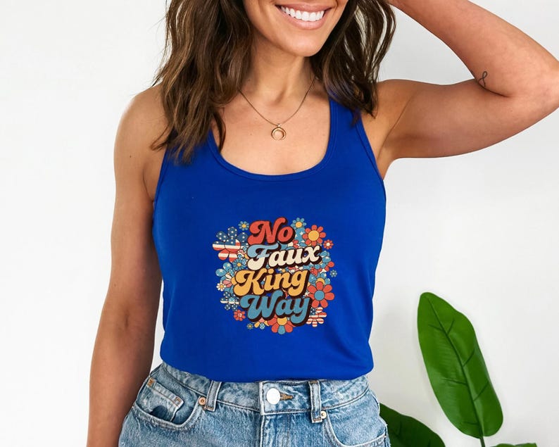 May include: A royal blue tank top with a colorful floral design and the text "No Faux King Way". The graphic includes red, white, and blue elements. The tank top is made of a soft material.