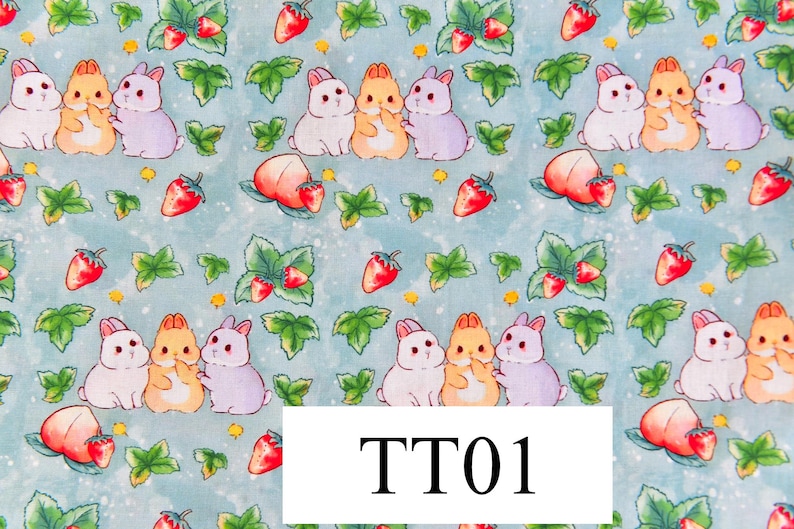 May include: A blue and white fabric with a repeating pattern of three bunnies and strawberries. The bunnies are white, orange, and purple. The strawberries are red. The text "TT01" is in the centre of the image.