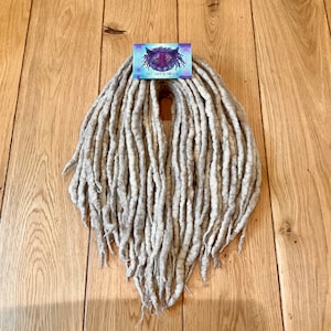 Może przedstawiać: Zestaw białych, wełnianych dredów, o długości około 50 cm, z małą wizytówką z napisem "Cat Lady's Creations".