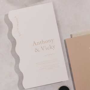 Könnte beinhalten: Eine weiße Hochzeitseinladung mit welligem Rand. Die Einladung ist für die Hochzeit von Anthony & Vicky am 26. Februar 2017 um 15:00 Uhr im The Gherkin, 10 St Mary Axe, London EC3A 8BP.