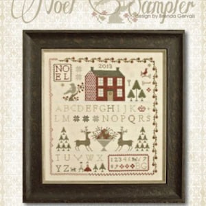 May include: A cross-stitch sampler pattern titled "Noel Sampler" designed by Brenda Gervais. The pattern features a red house with a white door and white trim, a bird, a Christmas tree, and the alphabet in a vintage style font. The pattern is framed in a dark brown frame.