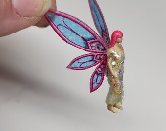 Minature  fairy garden and terrarium figurines. Light skin fairy in glittery dress. Sitting nude fairy miniatures. fancy fairy wings