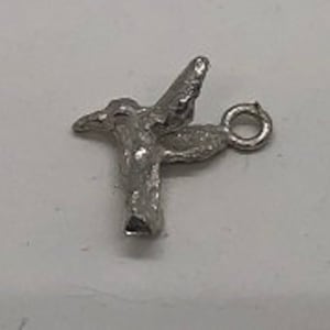 May include: Silver hummingbird charm with a loop for attaching to a necklace or bracelet.