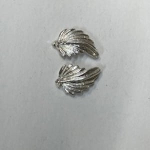May include: A pair of silver leaf-shaped earrings. The earrings are small and delicate, with a textured surface.