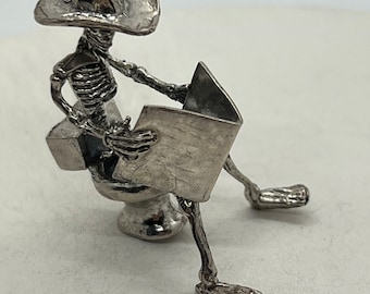 Cowboy On the Thrown Reading the Newspaper, Sterling Silver Bones Alive skeleton sculpture, hand cast by Don Norris in Tucson.