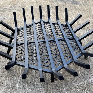 Op de afbeelding: Zwarte metalen vuurkorf met een ruitvormig draadgaas. De korf heeft 12 armen die zich naar buiten uitstrekken vanaf het midden.