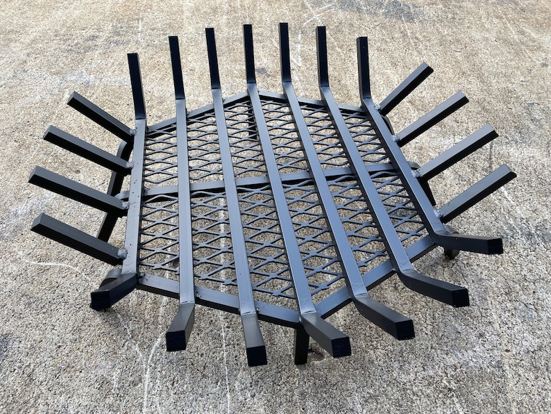 Op de afbeelding: Zwarte metalen vuurkorf met een ruitvormig draadgaas. De korf heeft 12 armen die zich naar buiten uitstrekken vanaf het midden.