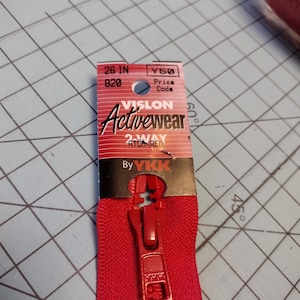 May include: A bright red 26-inch Vision Activewear zipper. The zipper is 2-way and labeled "ATOM RED". The tag includes the text "By YKK".