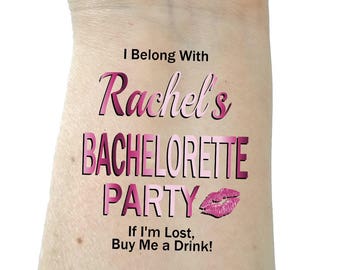 May include: Pink and white temporary tattoo with the text "I Belong With Rachel's Bachelorette Party" and a pink lip print. The text "If I'm Lost, Buy Me a Drink!" is also included.