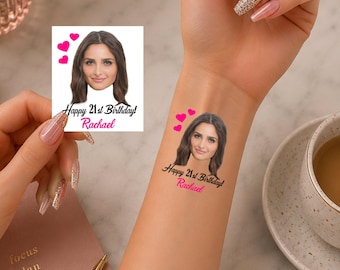 May include: A temporary tattoo featuring a portrait of a person with brown hair, three pink hearts, and the black text Happy 21st Birthday above the pink name Rachael. The design is shown on a square white backing and applied to a forearm.