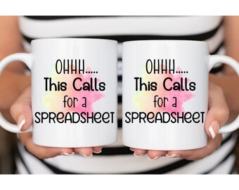 May include: Two white coffee mugs with a watercolour design and the text "OHHH... This Calls for a SPREADSHEET" on each mug.