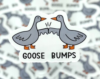 Pode incluir: Um adesivo branco com dois gansos cinzentos batendo os punhos. Os gansos têm pés e bicos laranja. O texto "GOOSE BUMPS" está impresso em preto abaixo dos gansos.