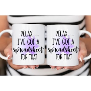 Peut inclure: Deux tasses à café blanches avec du texte noir qui dit "Relax..... I've got a spreadsheet for that". Le texte est sur un fond aquarelle violet.