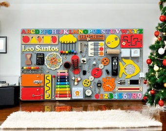May include: A colorful wooden activity board for children with a variety of textures, shapes, and activities. The board features a lock, a xylophone, a clock, a maze, a fish with beads, a chain, a gear, a zipper, a light switch, a remote control, and more. The board is labeled "Leo Santos" and includes the alphabet and numbers 1-9.