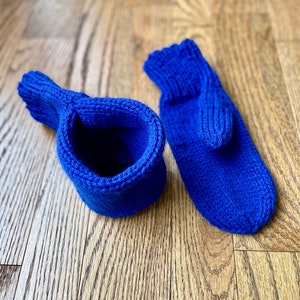 May include: A pair of blue knitted mittens. One mitten is turned inside out, showing the knit texture.