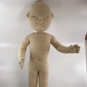 Peut inclure: Une poupée en crochet de couleur beige. La poupée a un design simple sans traits du visage ni vêtements.