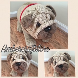 Puede incluir: Un juguete de peluche de perro pug tejido a crochet con un collar rojo. El juguete es beige y marrón y tiene una apariencia realista.