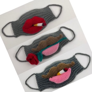 Puede incluir: Tres mascarillas faciales de crochet grises con diferentes diseños. La primera mascarilla tiene una boca de crochet roja con un cigarrillo. La segunda mascarilla tiene un bigote de crochet marrón con una boca de crochet rosa y una rosa de crochet verde. La tercera mascarilla tiene un bigote de crochet marrón con una boca de crochet rosa y un cigarrillo de crochet amarillo.