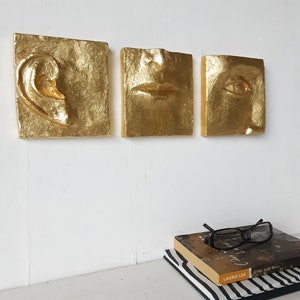 Three part ceramic wall sculpture with gold leaf surface