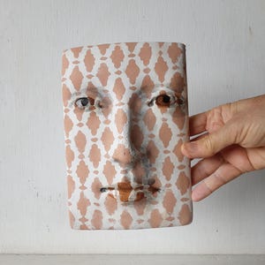 May include: A set of three ceramic mugs with a speckled, matte finish. Each mug features a different color: light blue, cream, and gray. The mugs have a simple, modern design and a comfortable handle.