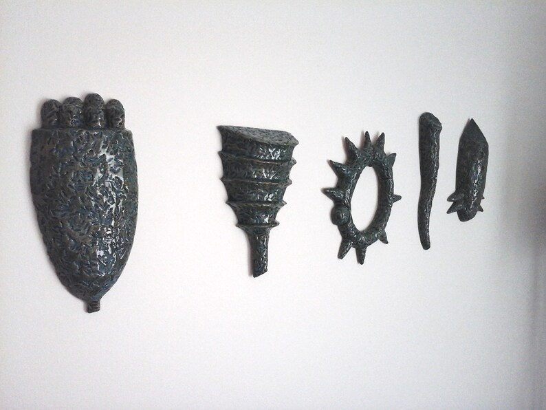 May include: Five ceramic wall sculptures in shades of blue and green. The sculptures are abstract and organic in shape, with textured surfaces.