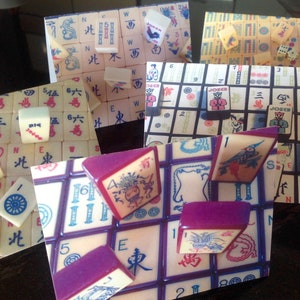 May include: A collection of six different Mahjong tile sets, each with unique designs and colors. The tiles are arranged in a variety of patterns and include traditional Chinese characters and symbols.