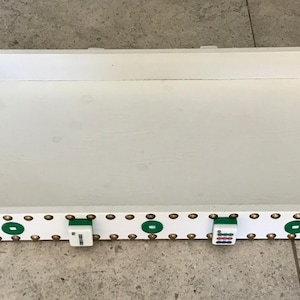 May include: White wooden tray with green trim and gold accents. The tray has a raised edge and a handle on one side. There are four mahjong tiles on the bottom edge of the tray.