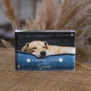 May include: A clear acrylic photo block with a picture of a dog sleeping on a blue bed. The text "FOREVER LOVED" and the name "Sam" are printed on the block.