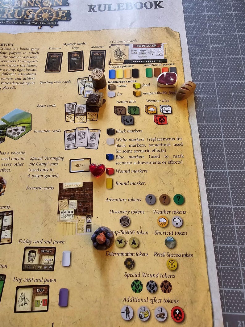 K&ouml;nnte beinhalten: Eine Nahaufnahme eines Spielbretts mit verschiedenen Spielfiguren und Spielsteinen. Das Spielbrett ist braun mit einem beigefarbenen Rand und tr&auml;gt den Text "Robinson Crusoe Abenteuer auf der verfluchten Insel" und "Regelbuch". Die Spielfiguren umfassen Holzw&uuml;rfel, schwarze und wei&szlig;e Markierungen sowie verschiedene Spielsteine.