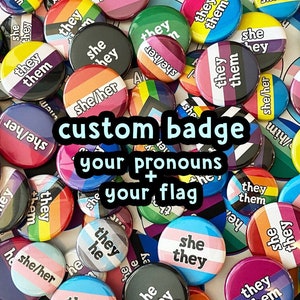 Op de afbeelding: Een verzameling kleurrijke, aangepaste badge-knoppen met verschillende pronomencombinaties en pride-vlaggen. De knoppen bevatten tekst zoals "they/them", "she/her" en "he/him", samen met verschillende regenboog- en genderbevestigende vlagontwerpen.