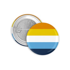 May include: A round button with a colorful design. The button features horizontal stripes in orange, yellow, white, light blue, and navy blue. The back of the button is silver with a pin.
