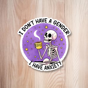May include: A sticker featuring a cartoon skeleton holding a yellow coffee mug. The skeleton is set against a purple background with stars and a crescent moon. Text reads, "I DON'T HAVE A GENDER I HAVE ANXIETY."