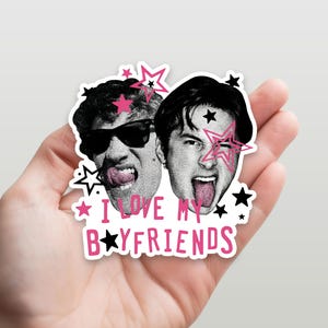Op de afbeelding: Een gestanste sticker met twee zwart-witportretten van personen die hun tong uitsteken, waarvan er &eacute;&eacute;n een zonnebril draagt. Het ontwerp bevat roze en zwarte sterren en de roze tekst "I LOVE MY B★YFRIENDS" in een speels lettertype.