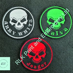May include: Three round black felt patches with white, green, and red embroidered skull designs. The patches have the text "Barry White's", "alva", and "Jeager" embroidered on them.
