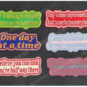 May include: Six colourful embroidered patches with different sayings. The patches are all rectangular and have a white background with colourful text. The sayings are: "It's always better when we're together", "One day at a time", "Believe you can and you're half way there", "Tony's Home Improvements Built to perfection everytime", "Congratulations on your engagement", and "The Elegance Parlor Hair & Beauty Salon".