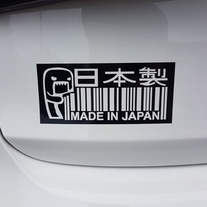 May include: Black and white sticker with a cartoon monster and barcode. The sticker says "日本製" and "MADE IN JAPAN".