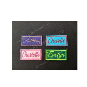 May include: Four embroidered name patches, each with a different name: "Anthony", "Charlie", "Charlotte", and "Evelyn". The names are in cursive script and each patch has a different colour scheme. The patches are rectangular with a border.