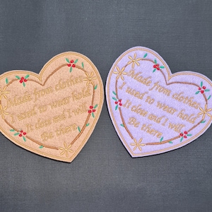 May include: Two heart-shaped fabric patches with embroidered text. The text on both patches reads "Made from clothes I used to wear hold It close and I will Be there". One patch is brown and the other is purple.