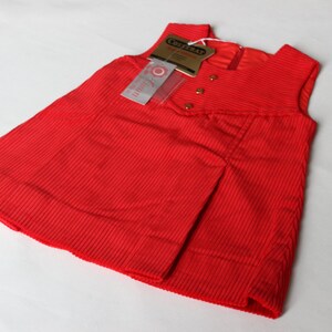 May include: A red sleeveless corduroy dress with a small tag that says "Craftsman" and "Little Girl".