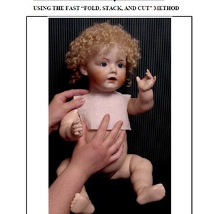 May include: A close-up of a porcelain doll with curly blonde hair, wearing a white dress. The doll is being held by a person's hands, demonstrating a method for dressing dolls.
