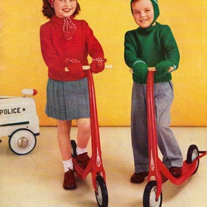 May include: Two children, a girl and a boy, are riding red scooters. The girl is wearing a red sweater, a red and white hat, and a gray skirt. The boy is wearing a green sweater and a green and white hat. Both scooters have red handlebars and wheels.