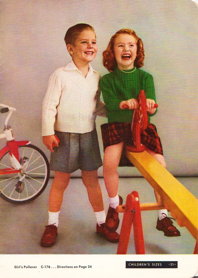 May include: Two children, a boy and a girl, are playing on a seesaw. The boy is wearing a white sweater and grey shorts. The girl is wearing a green sweater and a red and black plaid skirt. The seesaw is yellow and red.