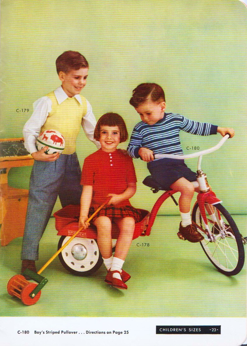 May include: Three children playing with a red wagon and a tricycle. The wagon has a white and red design and a wooden handle. The tricycle is red with a white seat and black wheels. The children are wearing casual clothing. The boy in the blue and white striped shirt is riding the tricycle. The girl in the red shirt is sitting in the wagon. The boy in the yellow shirt is pushing the wagon.