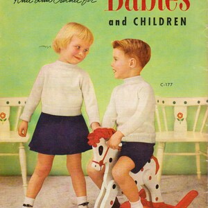 May include: A vintage book cover featuring a girl and boy in knitted clothing. The girl is wearing a white sweater and a dark blue skirt. The boy is wearing a white sweater and dark blue shorts. The boy is riding a rocking horse. The book cover is titled "Knit and Crochet for Babies and Children" and features the text "Chadwick's Red Heart Yarns".