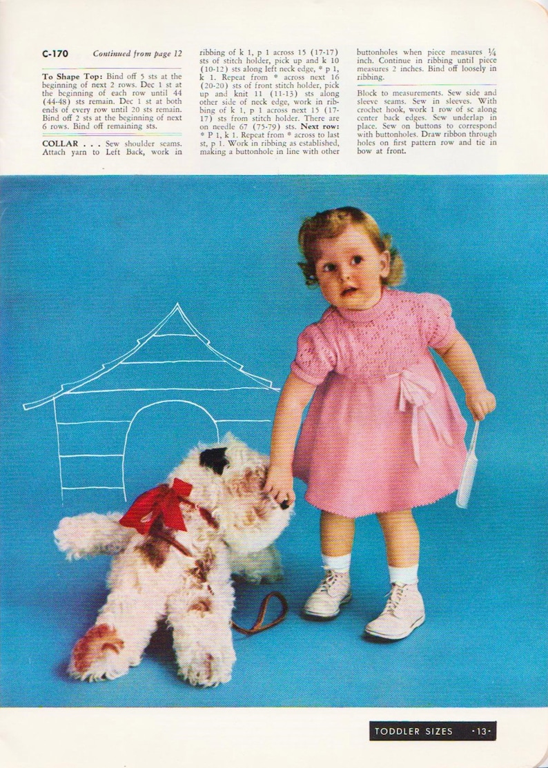 May include: A young girl in a pink knitted dress with a white collar and a bow at the waist, stands in front of a blue background. She is holding a white brush and looking at a white stuffed dog with a red bow. The text "TODDLER SIZES -13- " is at the bottom of the image.