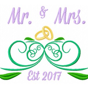 May include: Mr. & Mrs. wedding design with two gold rings, green swirls, and leaves. The text "Est 2017" is below the design.