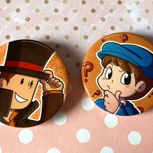 Op de afbeelding: Twee ronde knoopsgaten met cartoonfiguren. De eerste knoopsgat toont een man in een bruin pak en een zwarte hoge hoed, die zijn hoed afneemt. De tweede knoopsgat toont een jongen in een blauw shirt en een pet, met een bedachtzame uitdrukking en vraagtekens rond zijn hoofd.