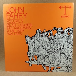 Op de afbeelding: Een vintage vinyl platenhoes met een zwart-witte illustratie van een groep mensen te paard. Het album is getiteld "John Fahey Volume 2: Death Chants, Breakdowns, & Military Waltzes" en is een uitgave van Takoma Records.