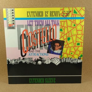 May include: Album cover for Elvis Costello and the Attractions' "Let Them All Talk" remix. The cover features a photo of Costello, with text in orange and black. The background is yellow and green.